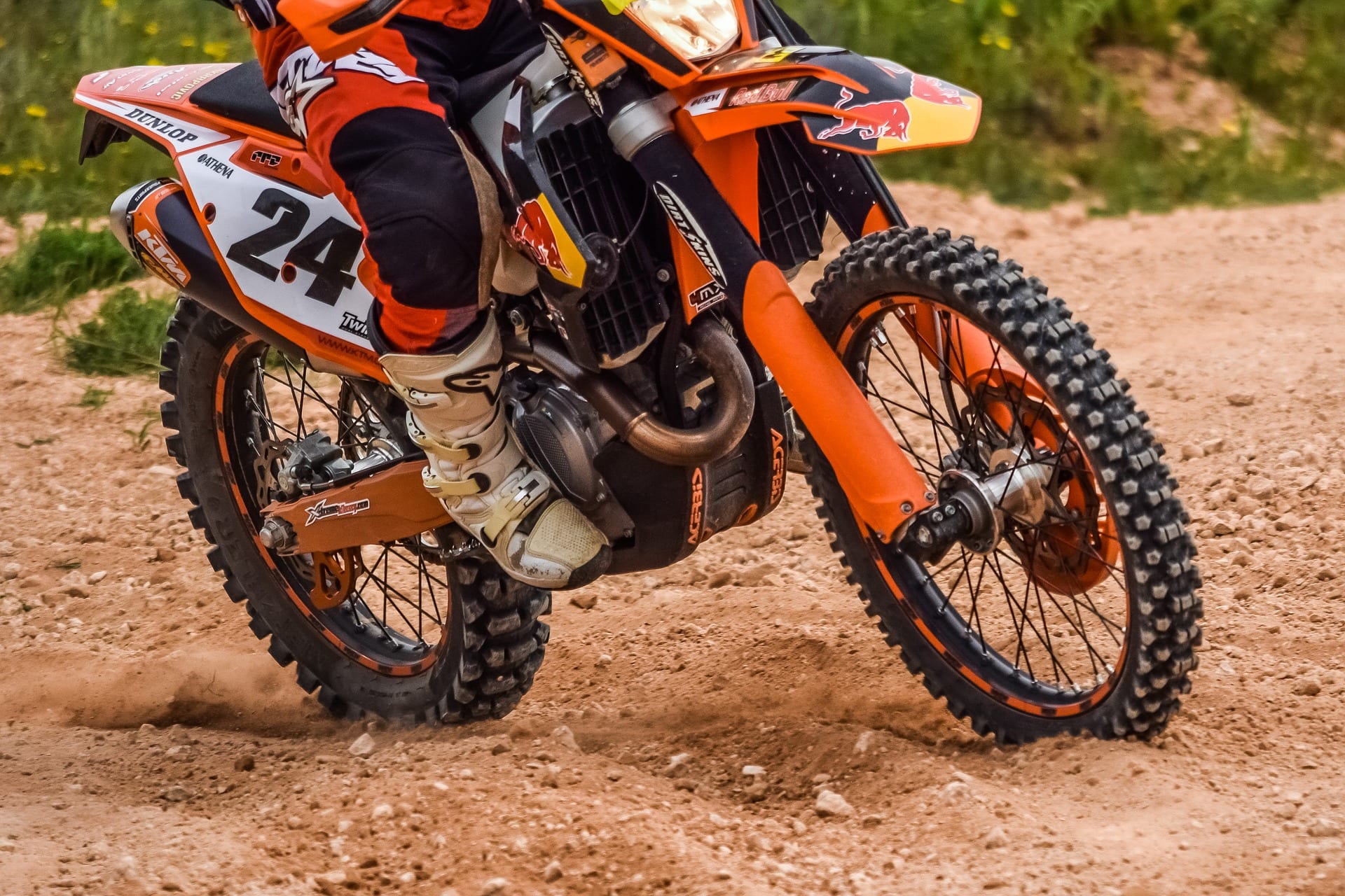 Focused on the wheels of an orange dirt bike